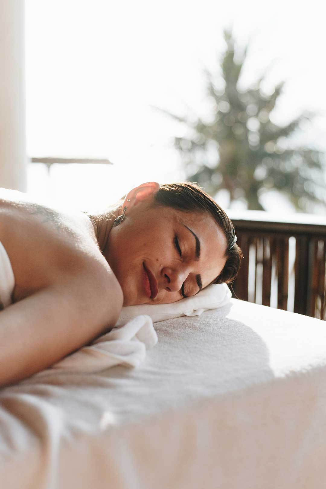 Woman relaxing during an outdoor spa treatment in warm sunlight